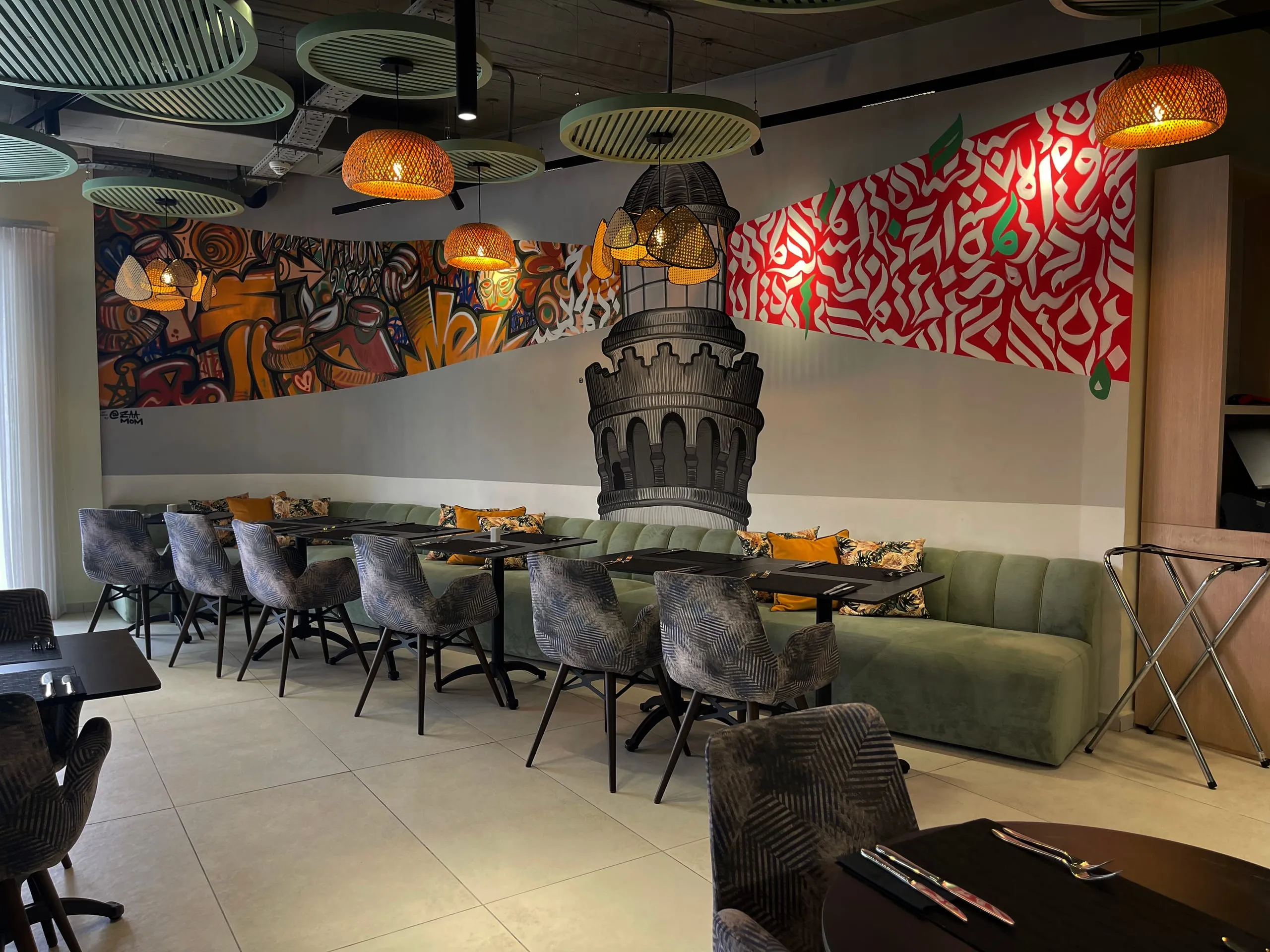 Restaurant wall with red and white Arabic calligraffiti and a painted tower