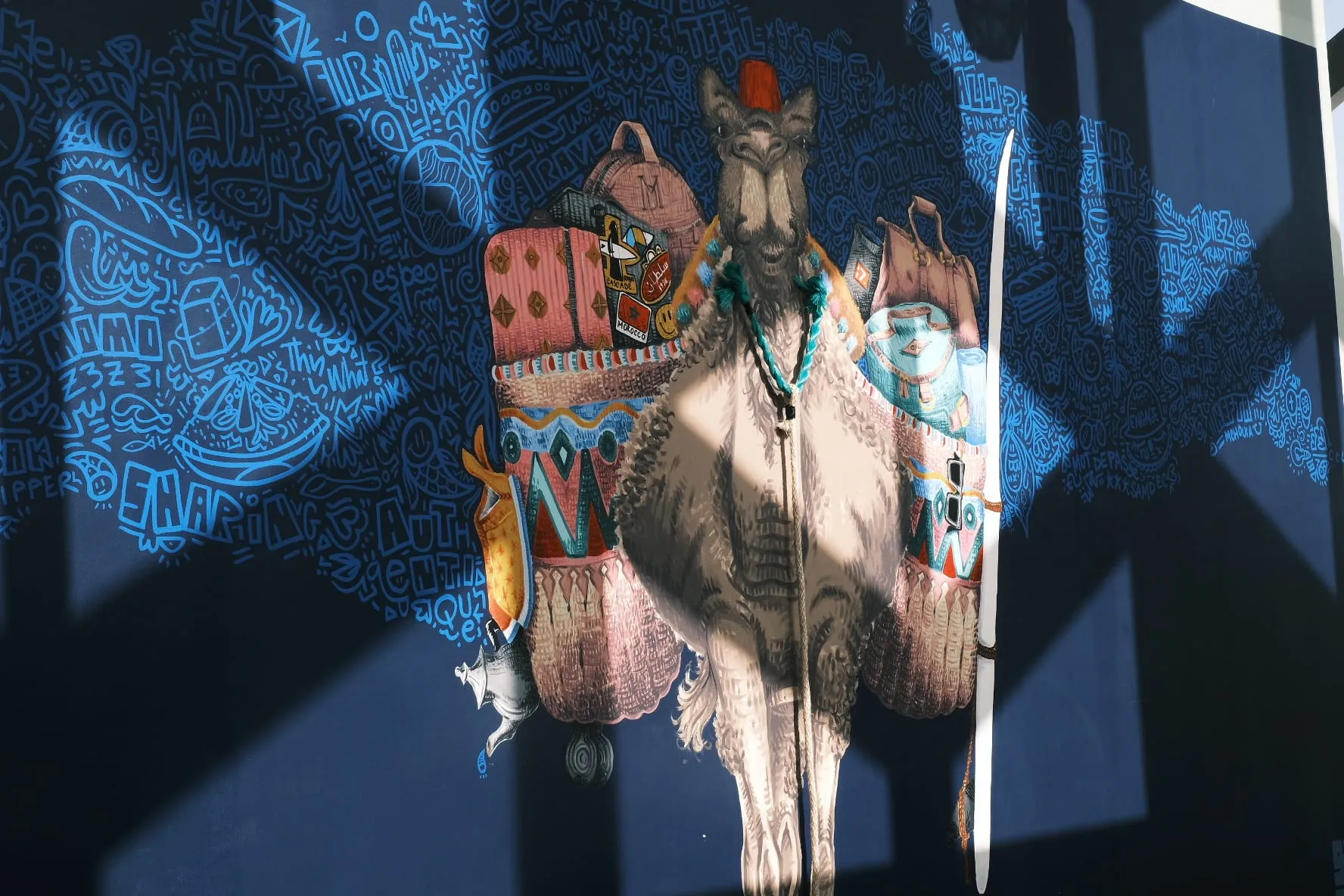 Camel mural surrounded by blue doodle linework on a deep blue wall